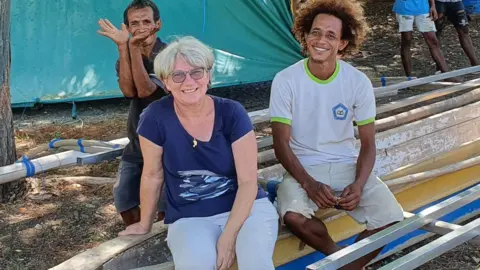 Mario Cabral Faustino Mauloko da Cunha, Karen Edyvane, Zacarias da Cunha seated on a dugout canoe in Subaun