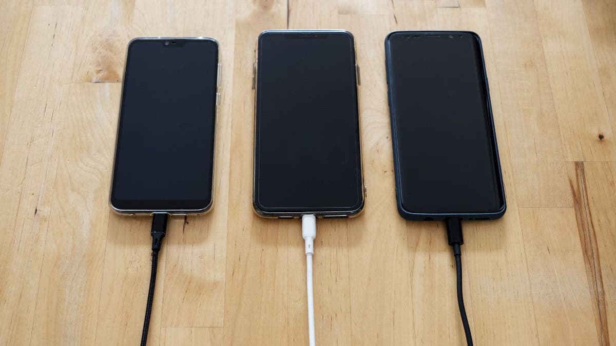 3 phones are plugged in with dark screens