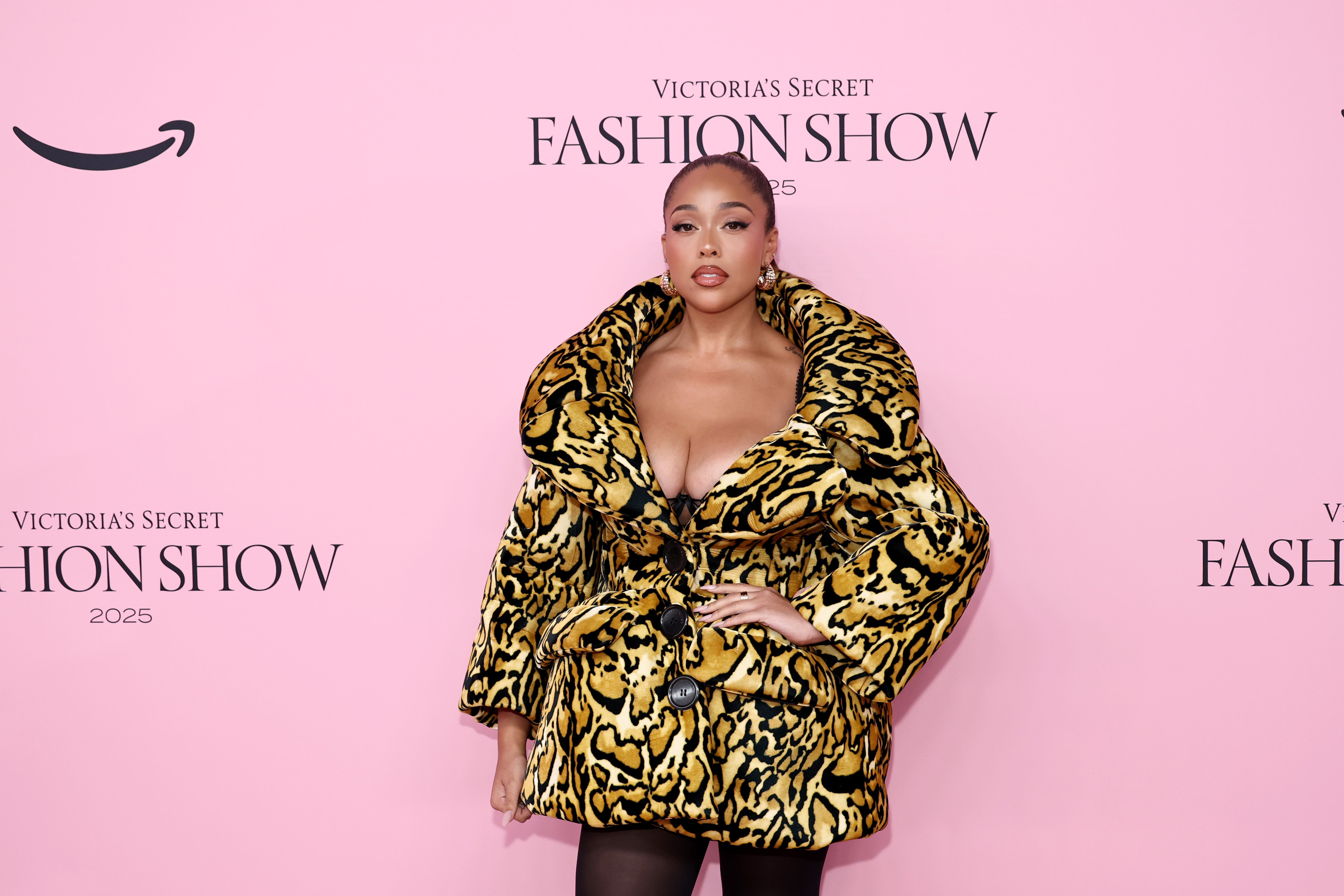 TV personality Jordyn Woods made a statement in a low-cut black and gold animal print bubble blazer dress complete with black tights
