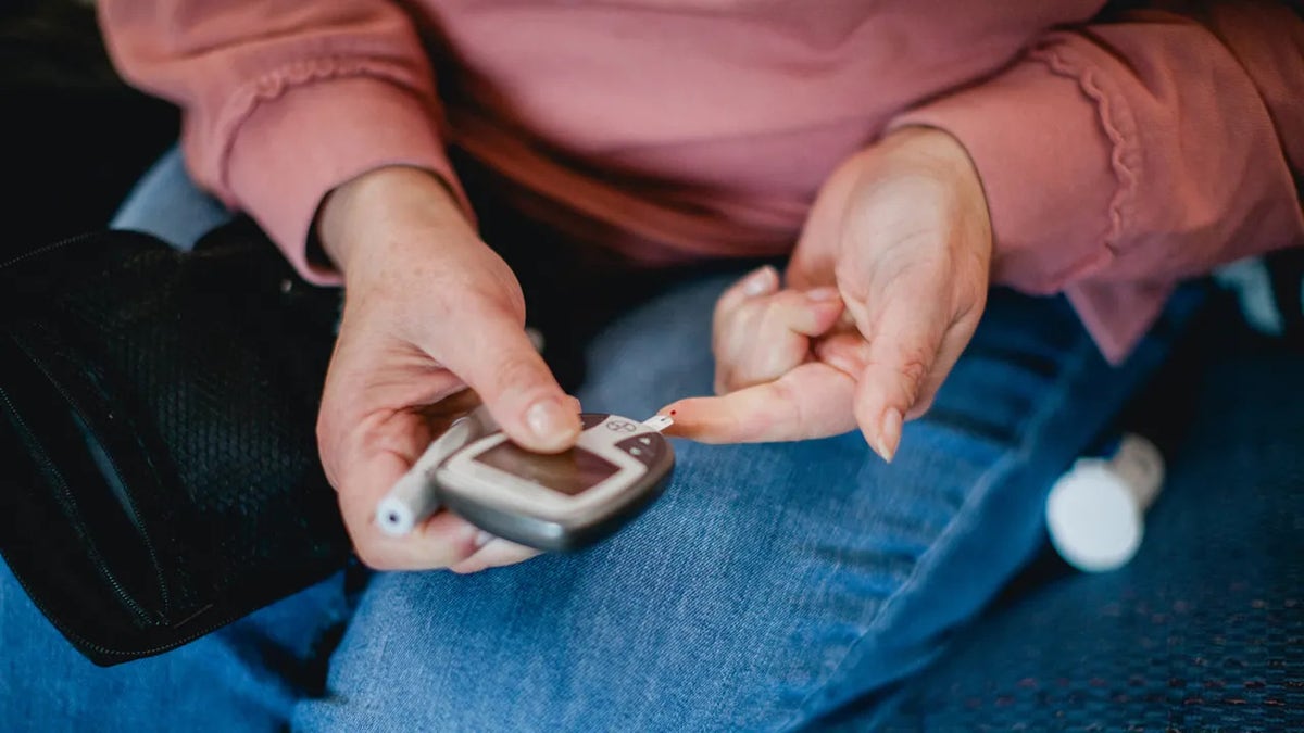 Type 2 diabetes, woman pricking her finger
